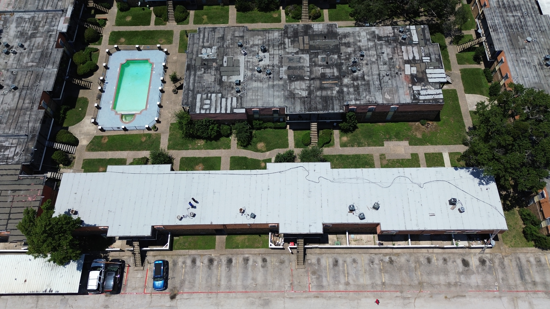 Aerial view of Houston multifamily community with aged modified-bitumen flat roofs before iSmart re-roof