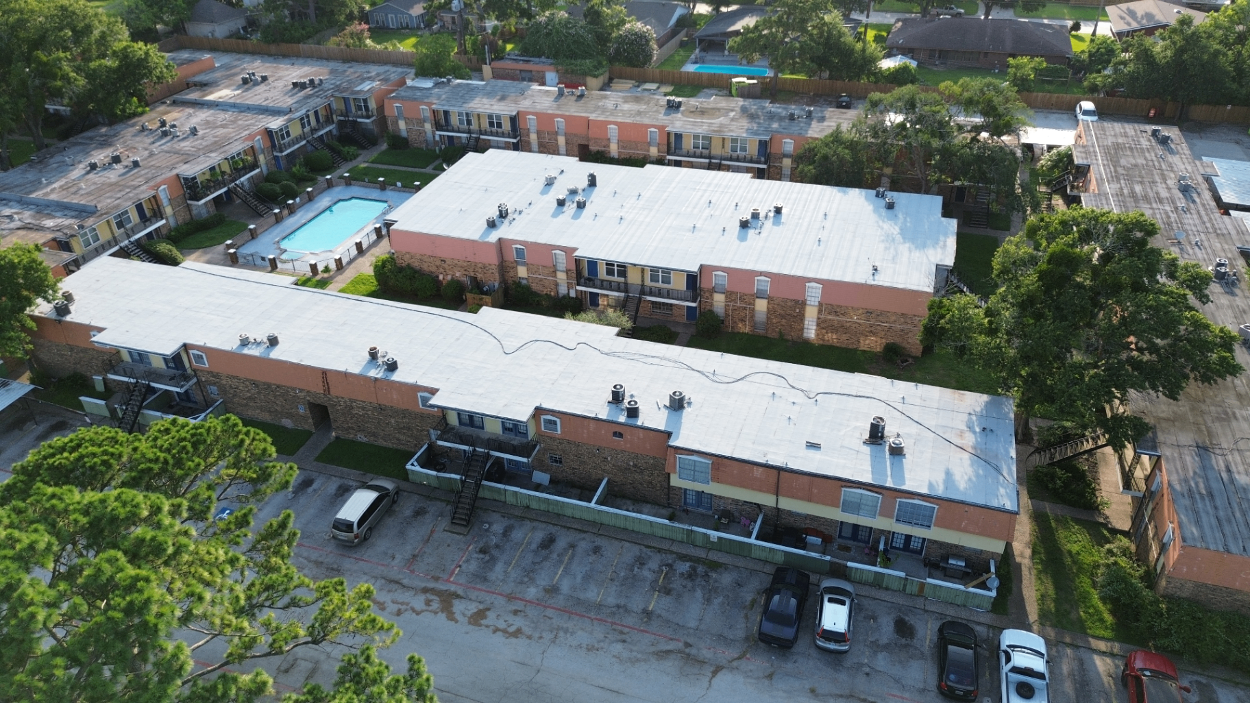 Aerial view of the same Houston multifamily community after iSmart installed a new white TPO single-ply roofing system